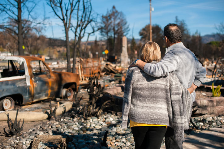 couple outside damaged house