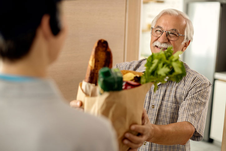 delivering groceries to senior gentleman