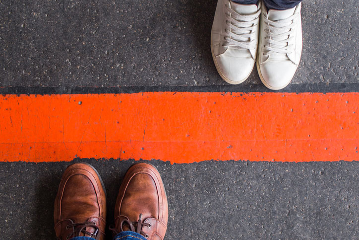 man and woman divided by line of paint on road