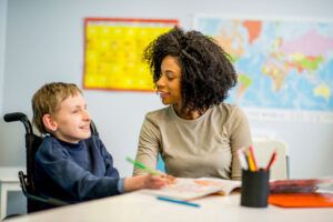 school social worker working with young boy in wheelchair