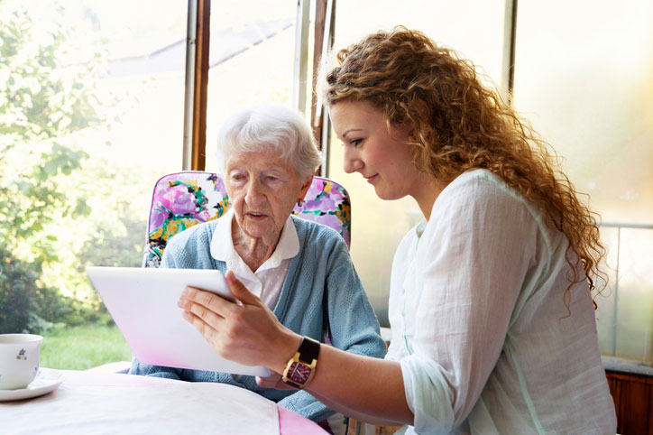 social worker and senior working on tablet