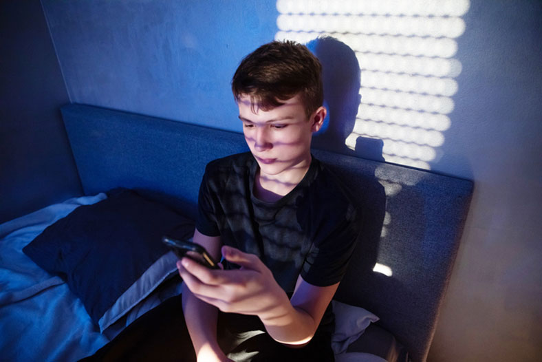 teen on cell phone at night