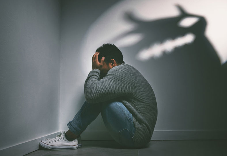 traumatized man in corner of bedroom