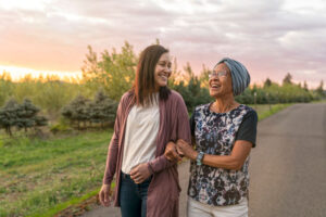 young woman walking elderly woman down county road